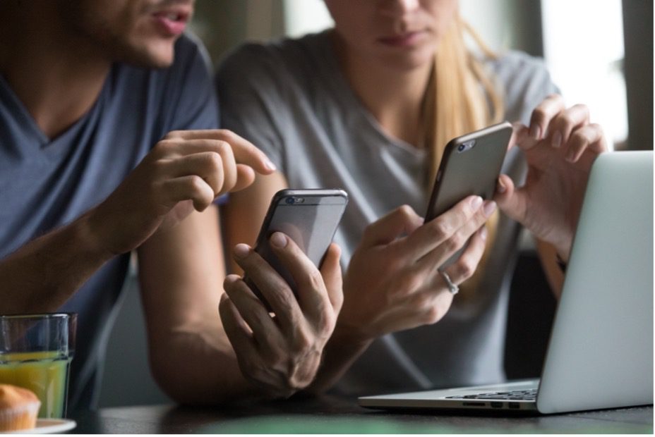 Two people checking their phone
