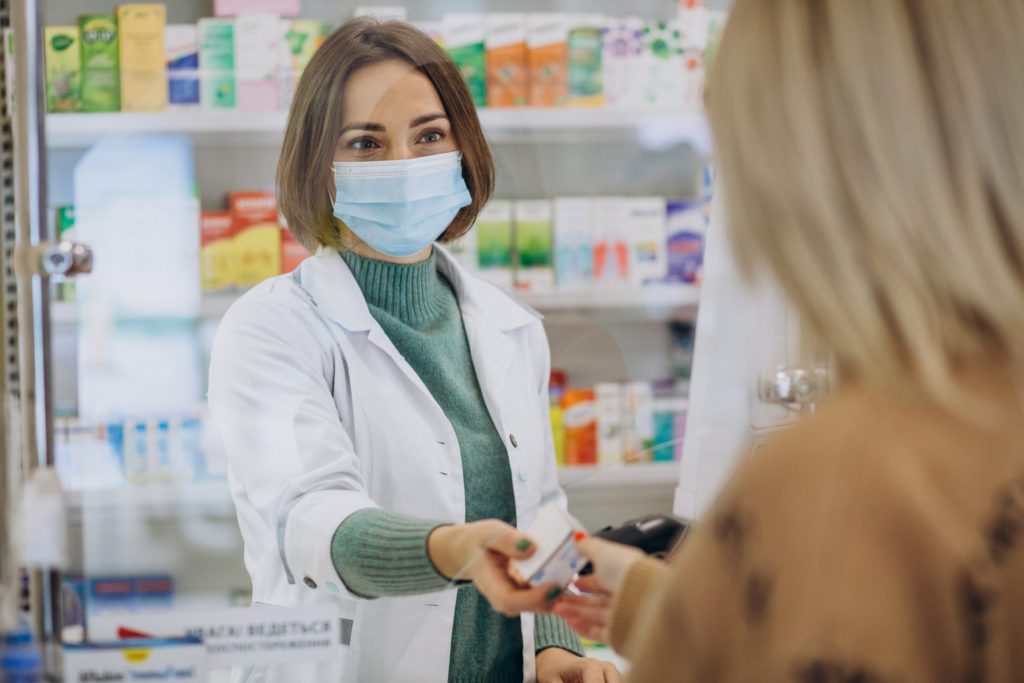 Pharmasict serving customer at drug store